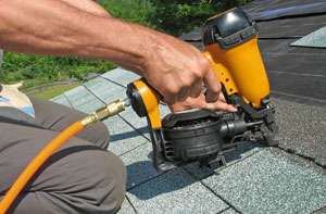 Northern Lights Exteriors Employee using a commercial stapler to install roof shingles