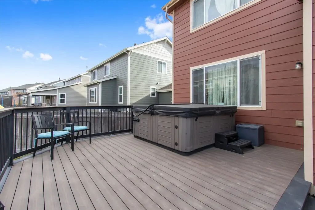 Deckorators Voyage composite deck in dark slate with a khaya frame and a hot tub