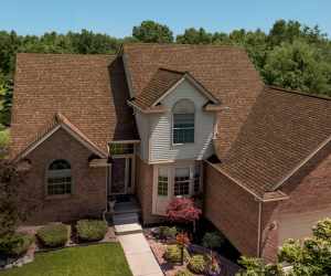 Large suburban home with new, brown shingle roofing