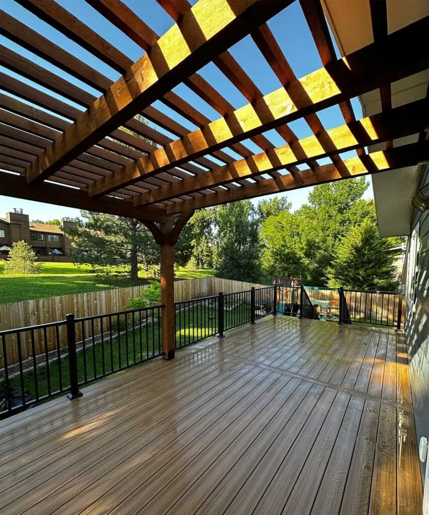 Custom wood pergola over a composite deck in a fenced Colorado back garden