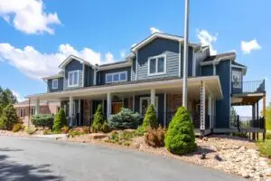 A modern two story home with blue James Hardie board siding and trees out front.