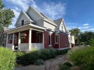 Denver exterior remodel with James Hardie Pearl Gray siding, Arctic White trim, and Allura half-round gable accents.