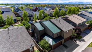 Denver home remodel with green standing seam metal roofing built for hail, wind, and snow.