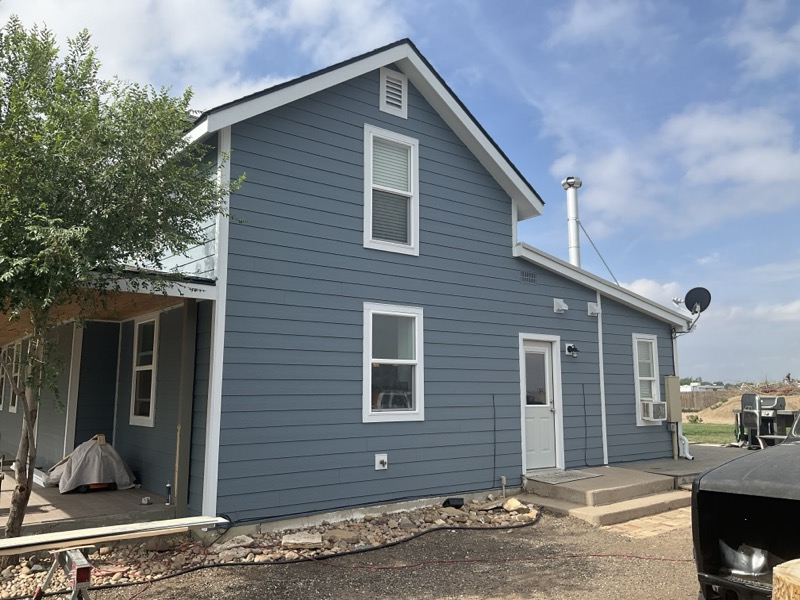 Fort Lupton home with James Hardie Boothbay Blue siding and Arctic White trim installed by Northern Lights Exteriors