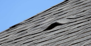 Wind damaged roof with lifted shingles after Colorado storm