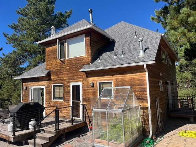 Before photo of a Boulder CO mountain home prior to James Hardie Woodtone fire-rated siding replacement by Northern Lights Exteriors