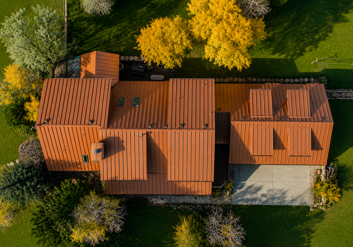 Aerial drone view of a custom standing seam metal roof installed by Northern Lights Exteriors in Berthoud, Colorado, showcasing precision metal roofing panels, modern architectural design, and long-lasting weather-resistant performance.