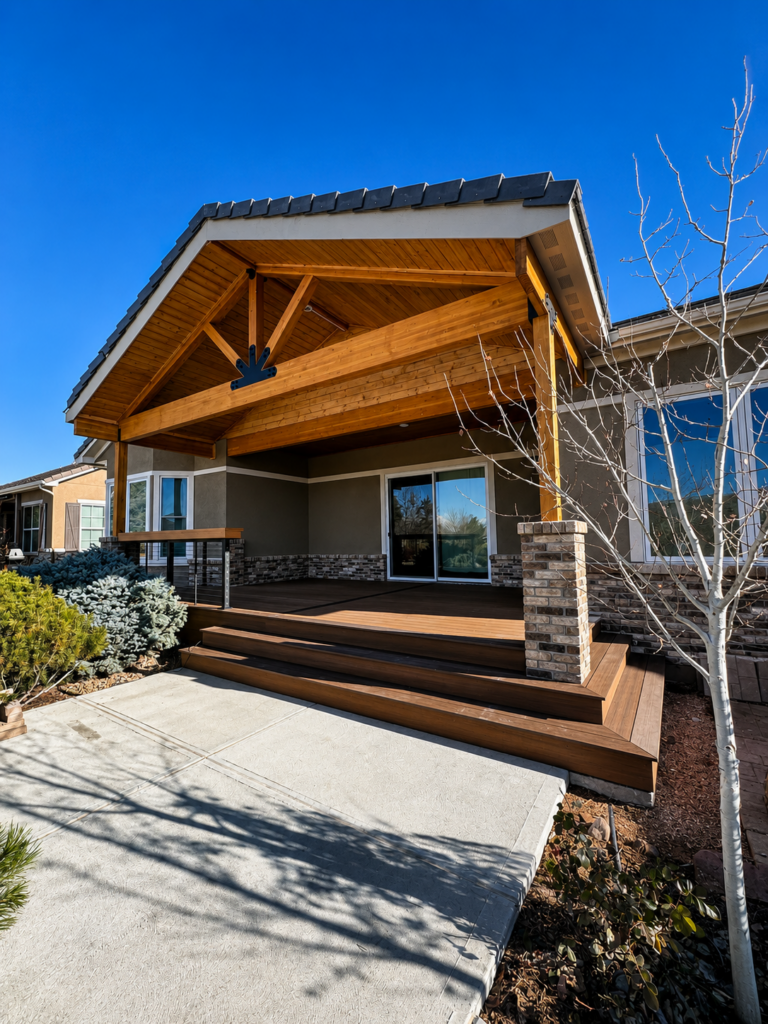 Gable-roofed covered patio with exposed timber truss, tongue-and-groove ceiling and brick columns on a Broomfield, Colorado home built by Northern Lights Exteriors