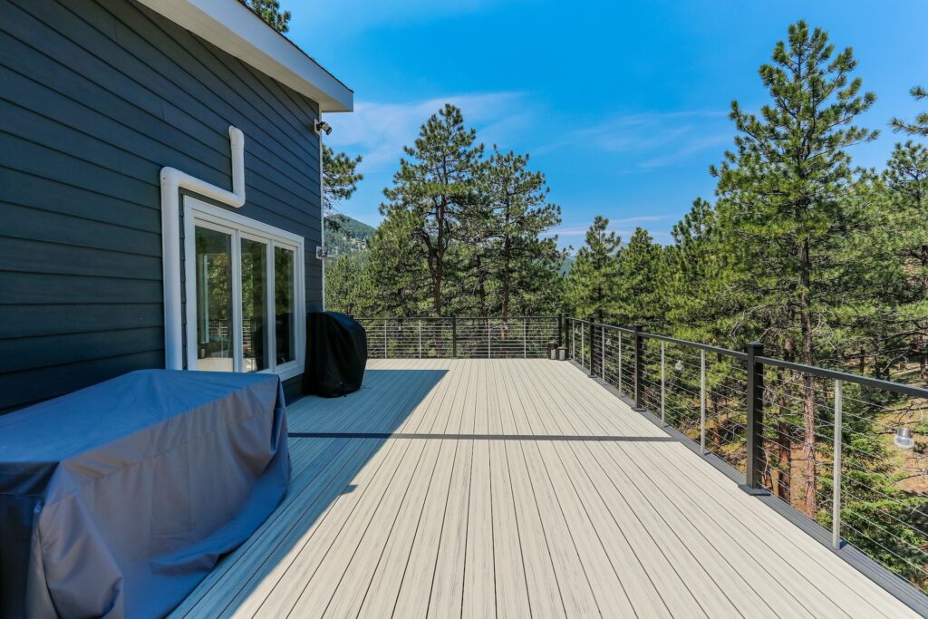 Deckorators Voyage composite deck in Tundra with dark slate cable railing overlooking the Colorado foothills