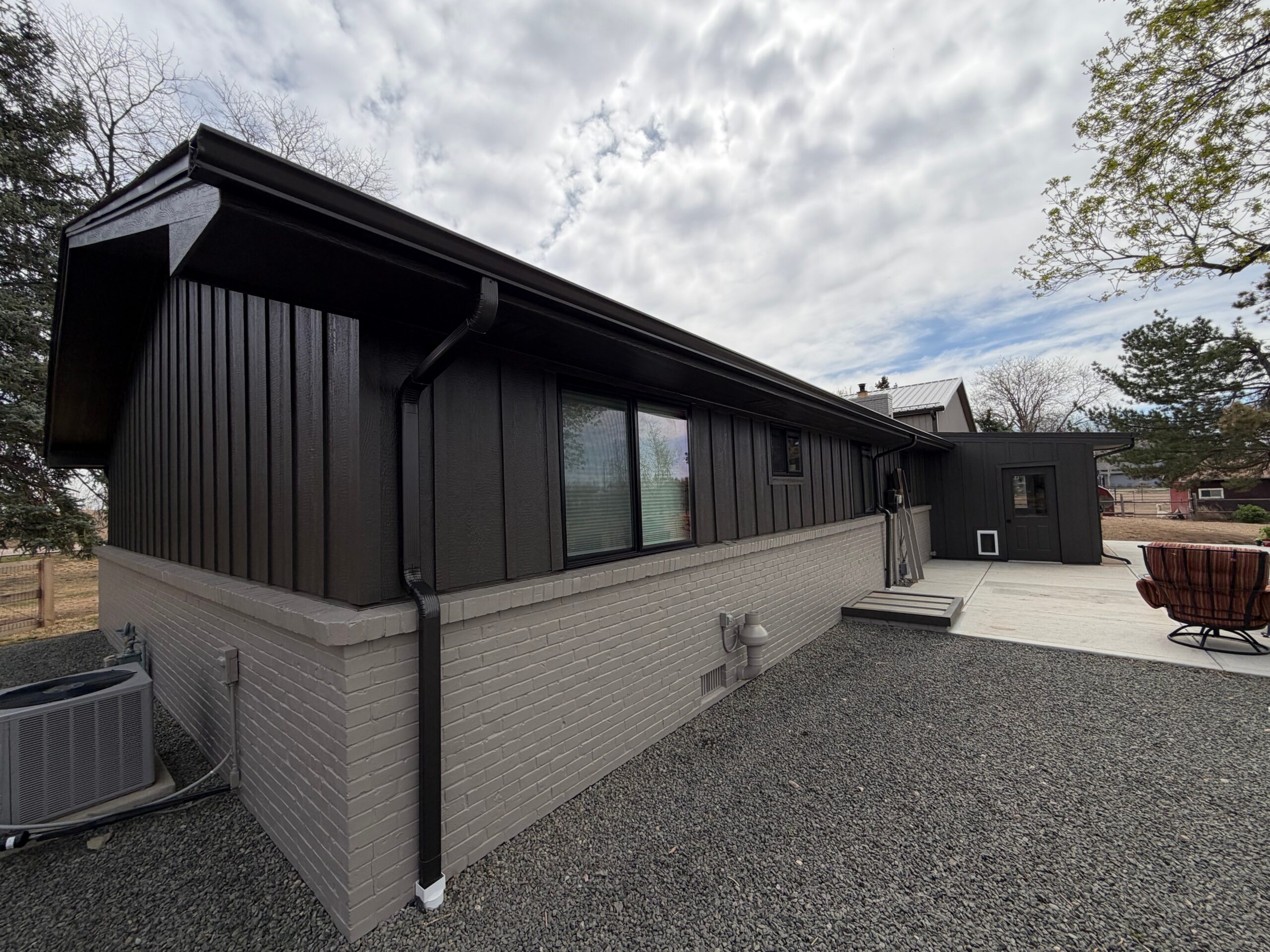 Multi-trade exterior remodel in Erie, Colorado featuring primed and painted LP SmartSide engineered wood siding, Pella replacement windows, energy-efficient exterior doors and modern black trim, by Northern Lights Exteriors