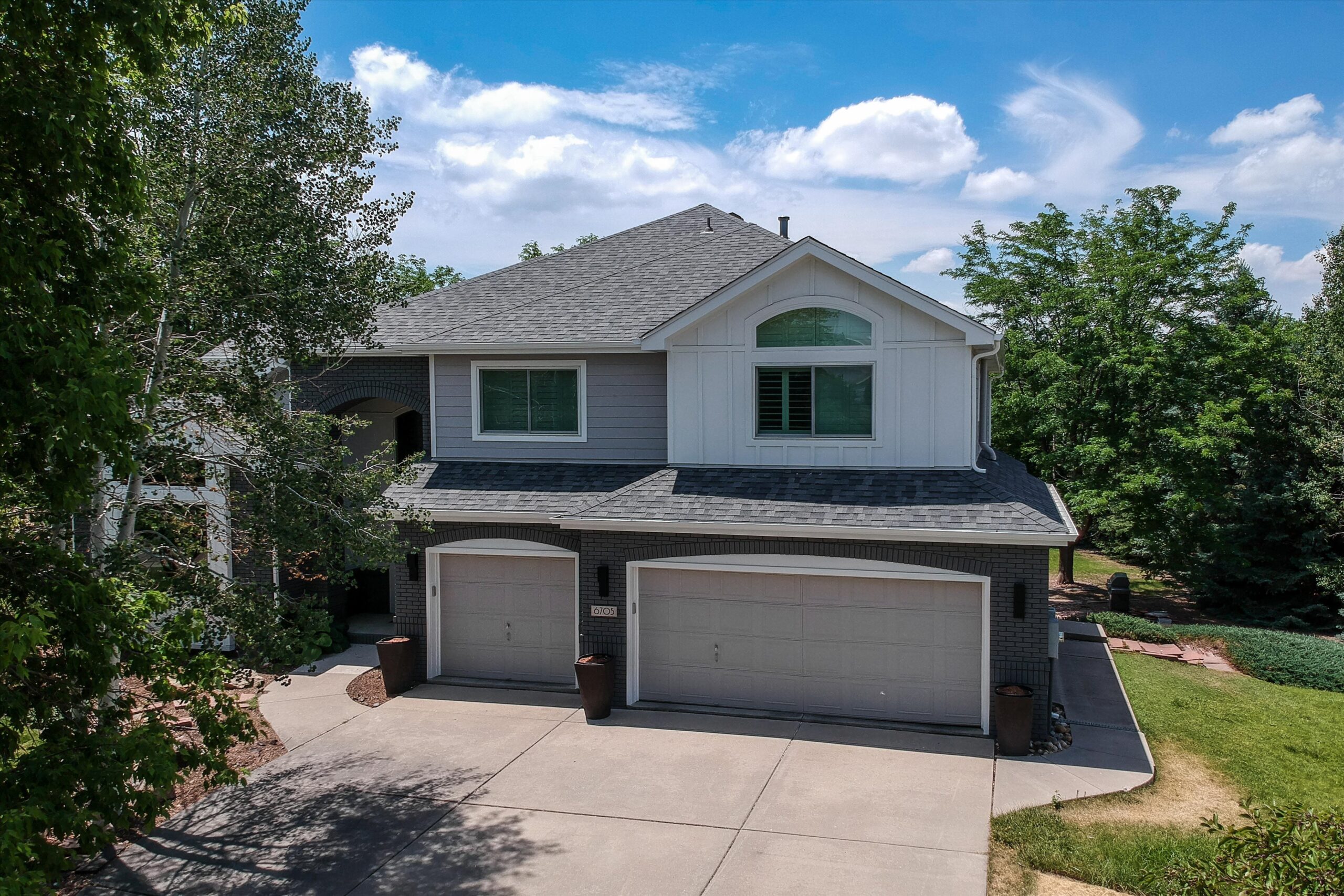 After photo of a Fort Collins CO home with James Hardie Pearl Gray lap siding and Arctic White board and batten accents