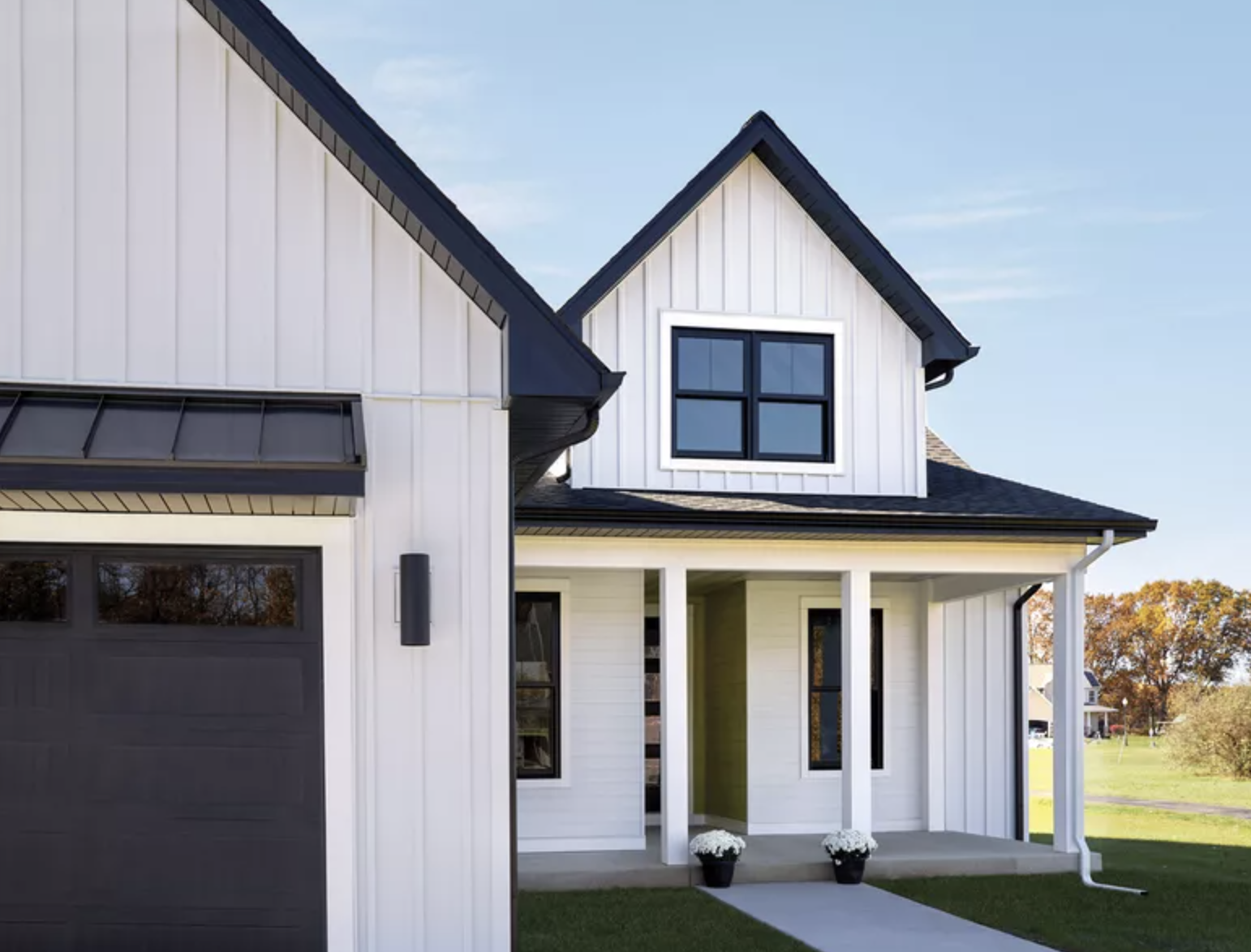 Modern farmhouse exterior inspiration featuring Quality Edge metal board and batten siding in a crisp white finish with black trim, black-framed windows, and contemporary vertical metal siding design for durability, low maintenance, and curb appeal