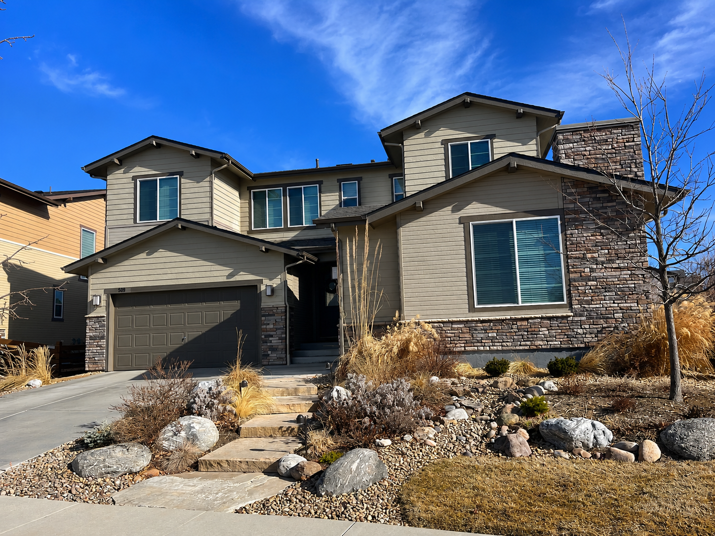 Erie, Colorado home featuring a new Class 4 impact-resistant asphalt shingle roof, replacement windows, exterior painting, seamless gutters, and stone accents completed by Northern Lights Exteriors following hail storm damage. This comprehensive exterior restoration improved curb appeal, weather protection, energy efficiency, and long-term durability for Colorado's demanding climate.