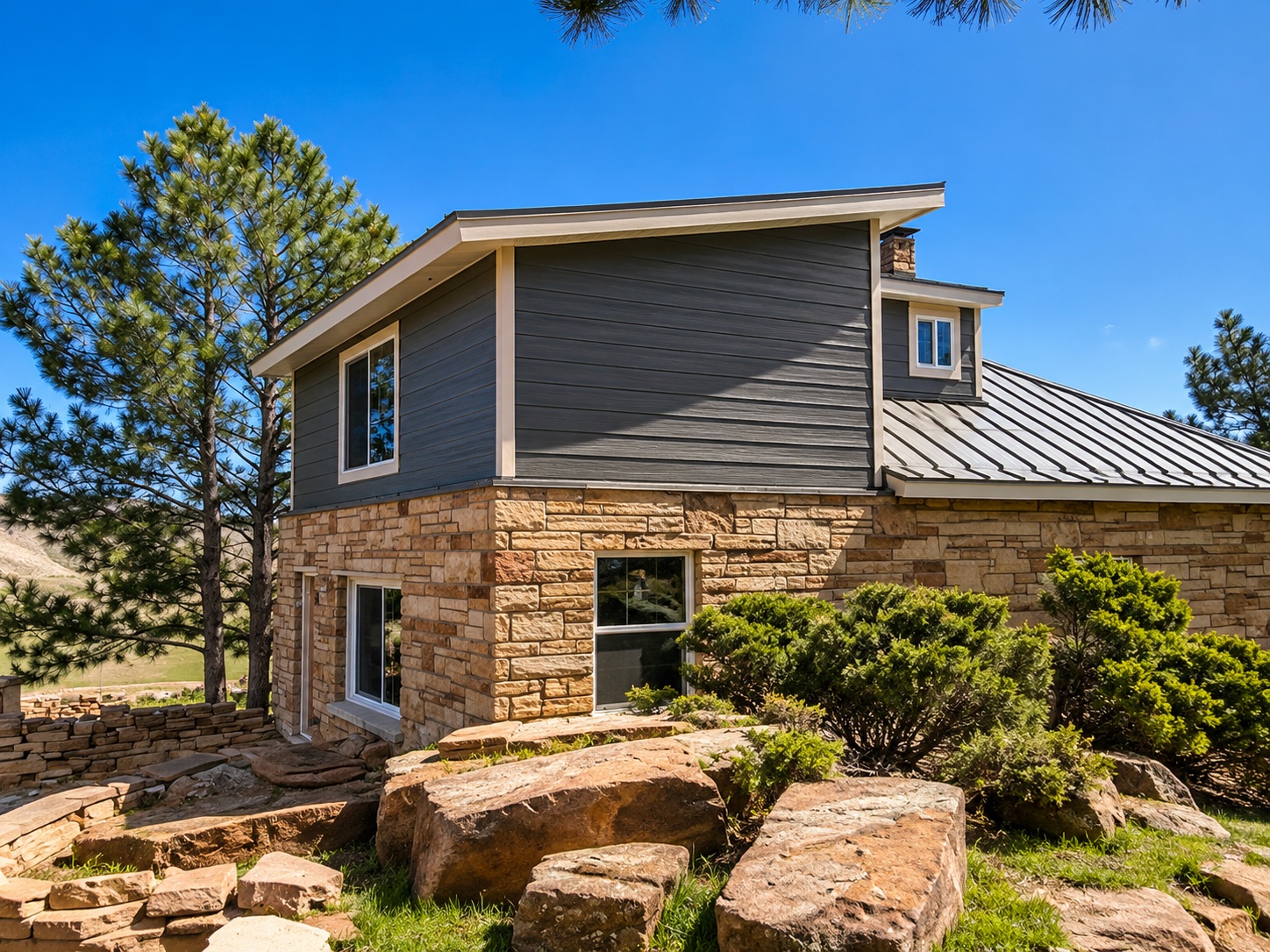 Berthoud home with James Hardie Gray Slate siding and Cobblestone trim installed by Northern Lights Exteriors, designed to complement the natural stone masonry.