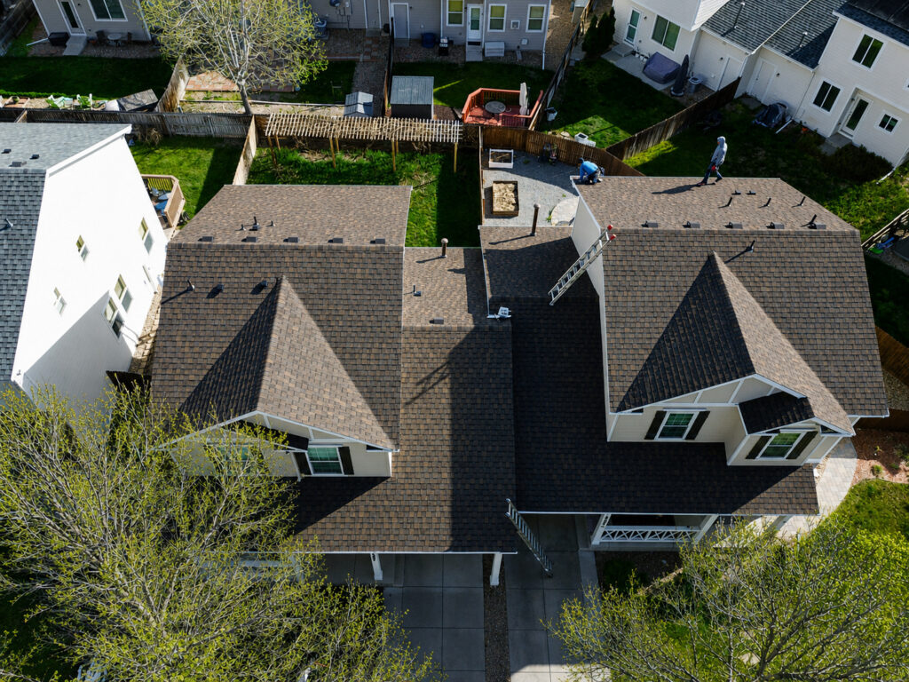 Aerial view of an asphalt shingle roof replacement in progress in Thornton, Colorado, bordering Northglenn.